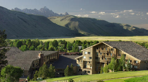 Luxury mountain lodging in front of green mountain range