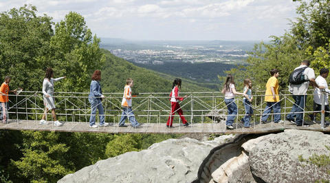 Group of people crossing bridge above Smoky Mountains